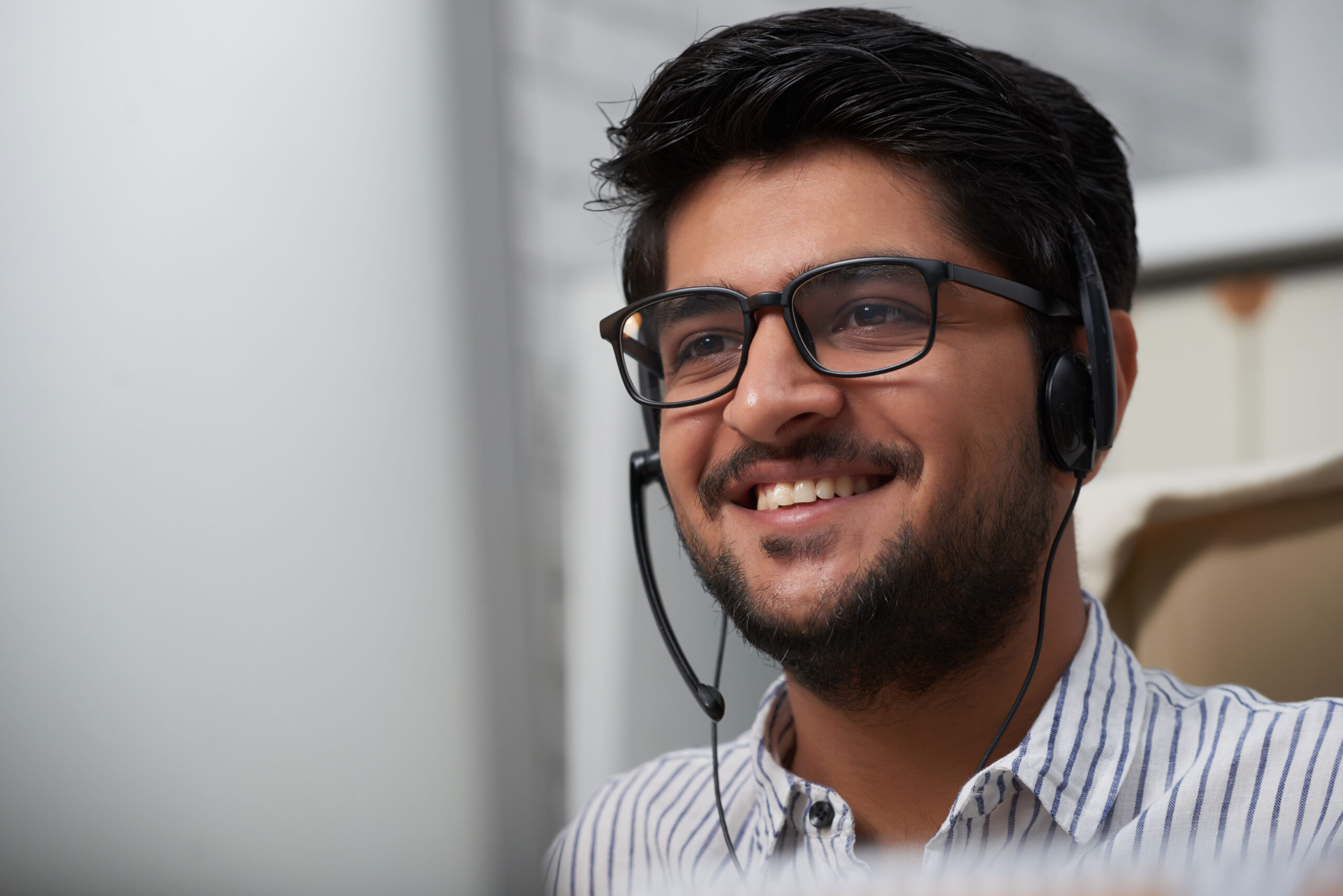 A man with headphones on smiling.